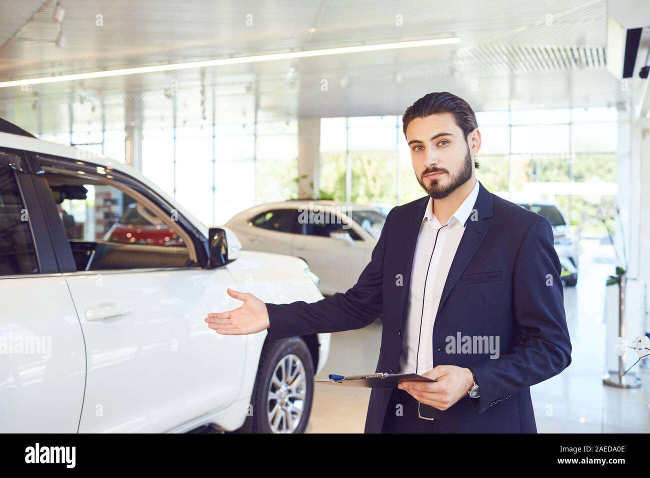 A car dealer shows a vehicle in a showroom. Auto business.Buying rental
