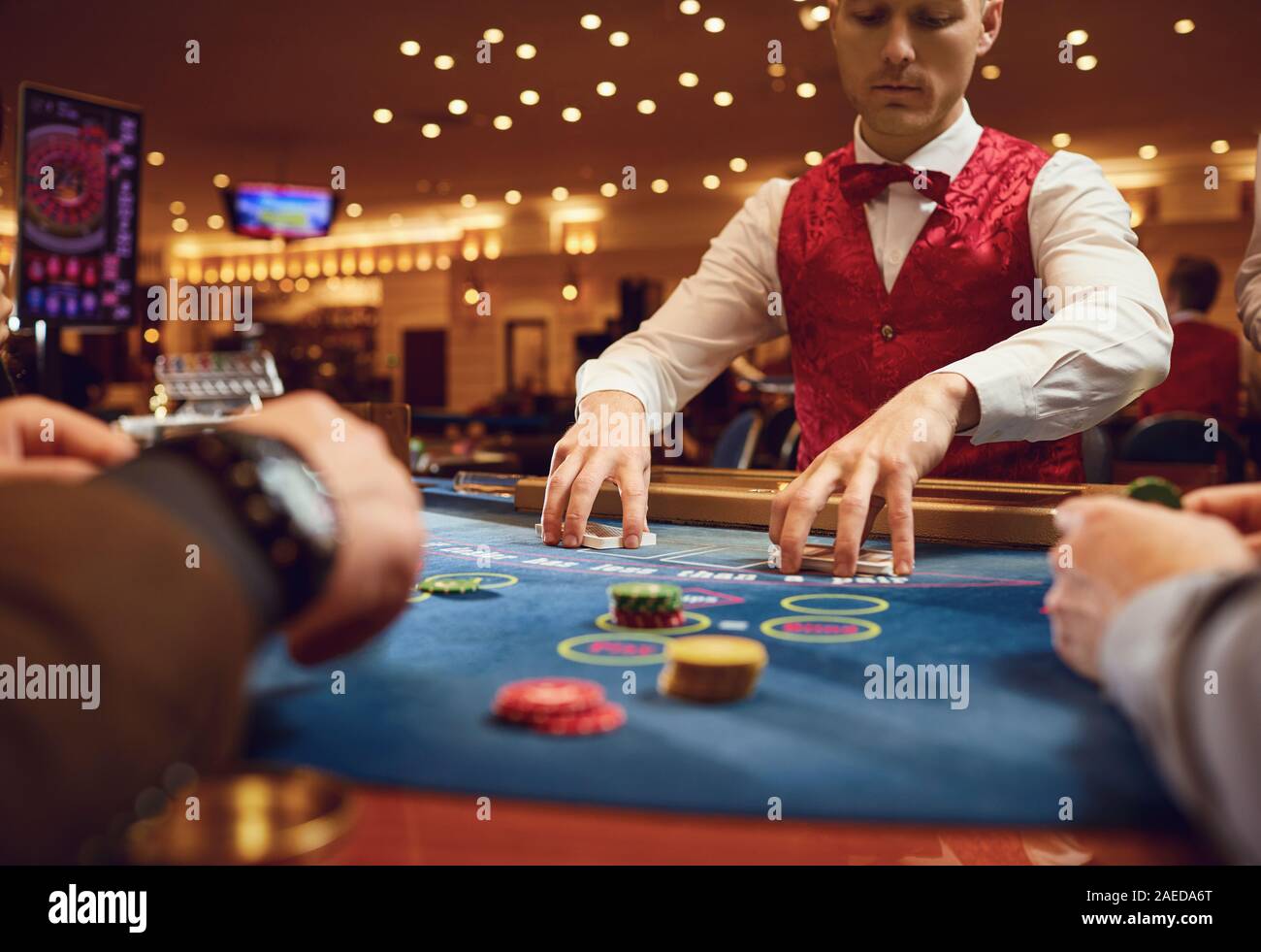The Croupier Holds Poker Cards In His Hands At A Table In A Casino