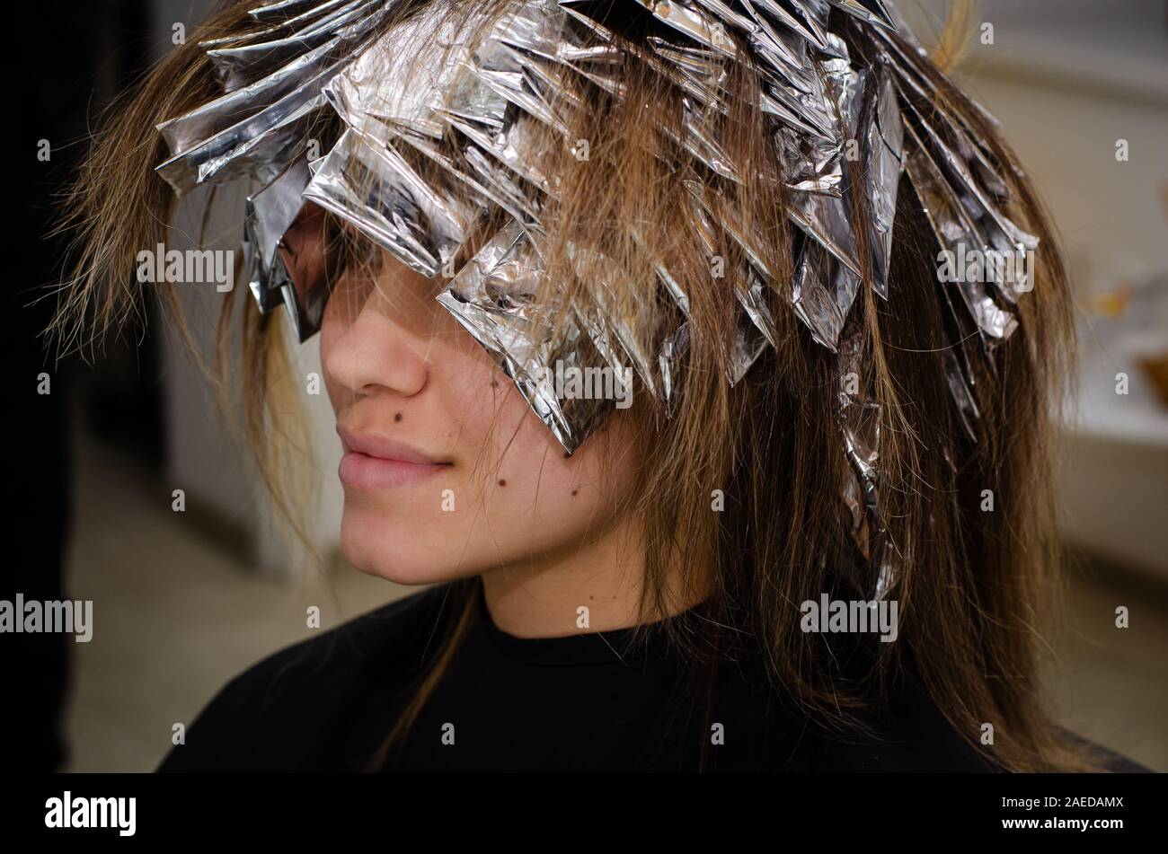 Beautiful young woman with foil on her hair. Bleaching or dyeing process.  Beauty salon, fashionable hair coloring Stock Photo - Alamy