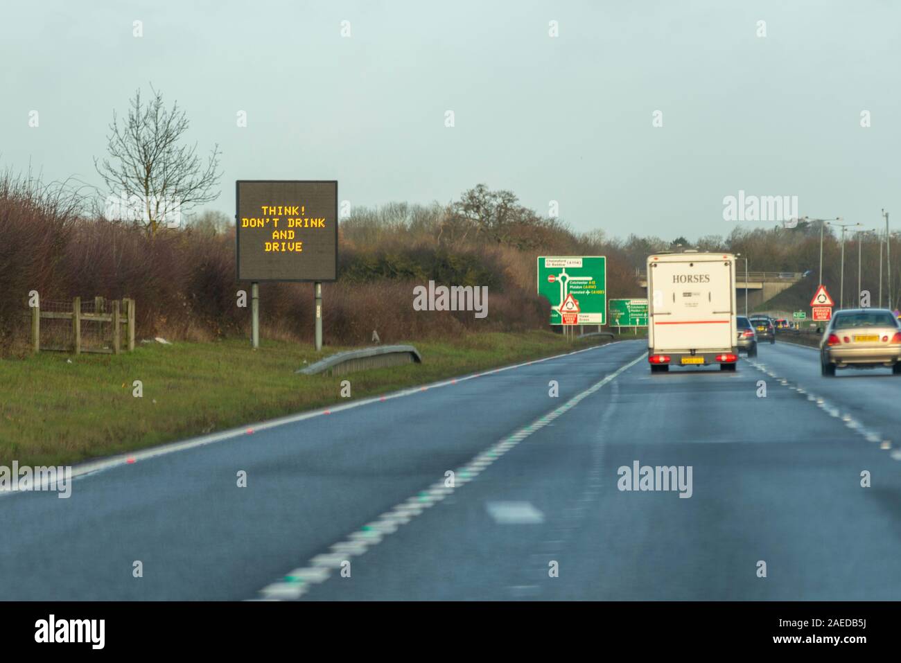 Think, Don't drink and drive matrix sign with vehicles approaching A12 Chelmsford, Essex, UK driving on a stretch of A130 duel carriageway. Warning Stock Photo