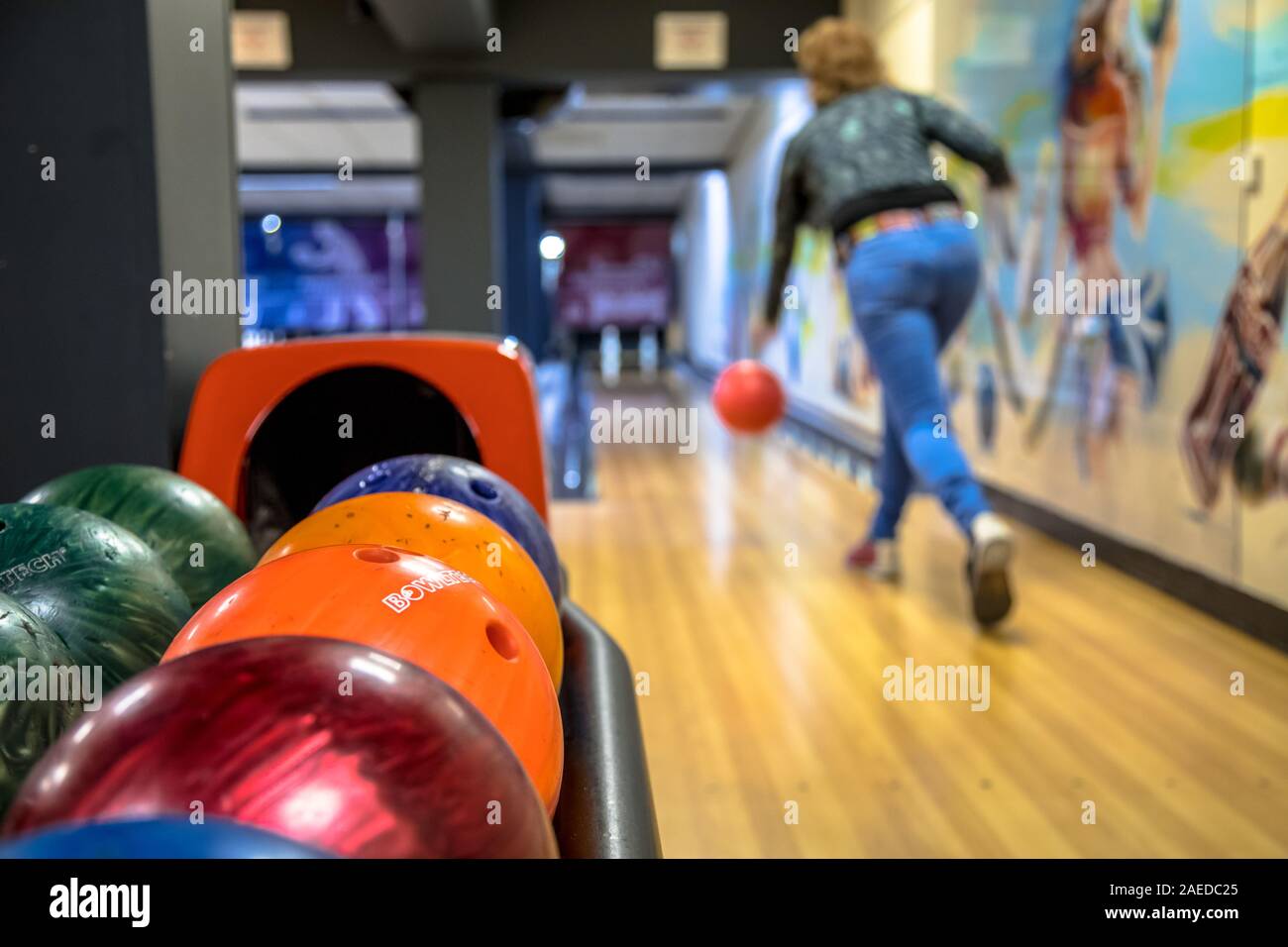 Woman throwing bowling ball on indoor bowling alley Stock Photo