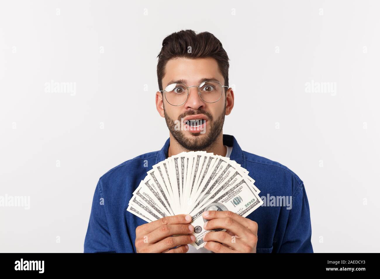 Attractive man is holding cash money in one hand, on isolated white ...