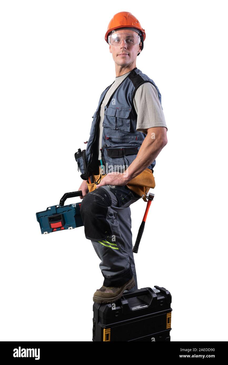 Builder with tools in cases. In a helmet and glasses, and unloading. Stock Photo