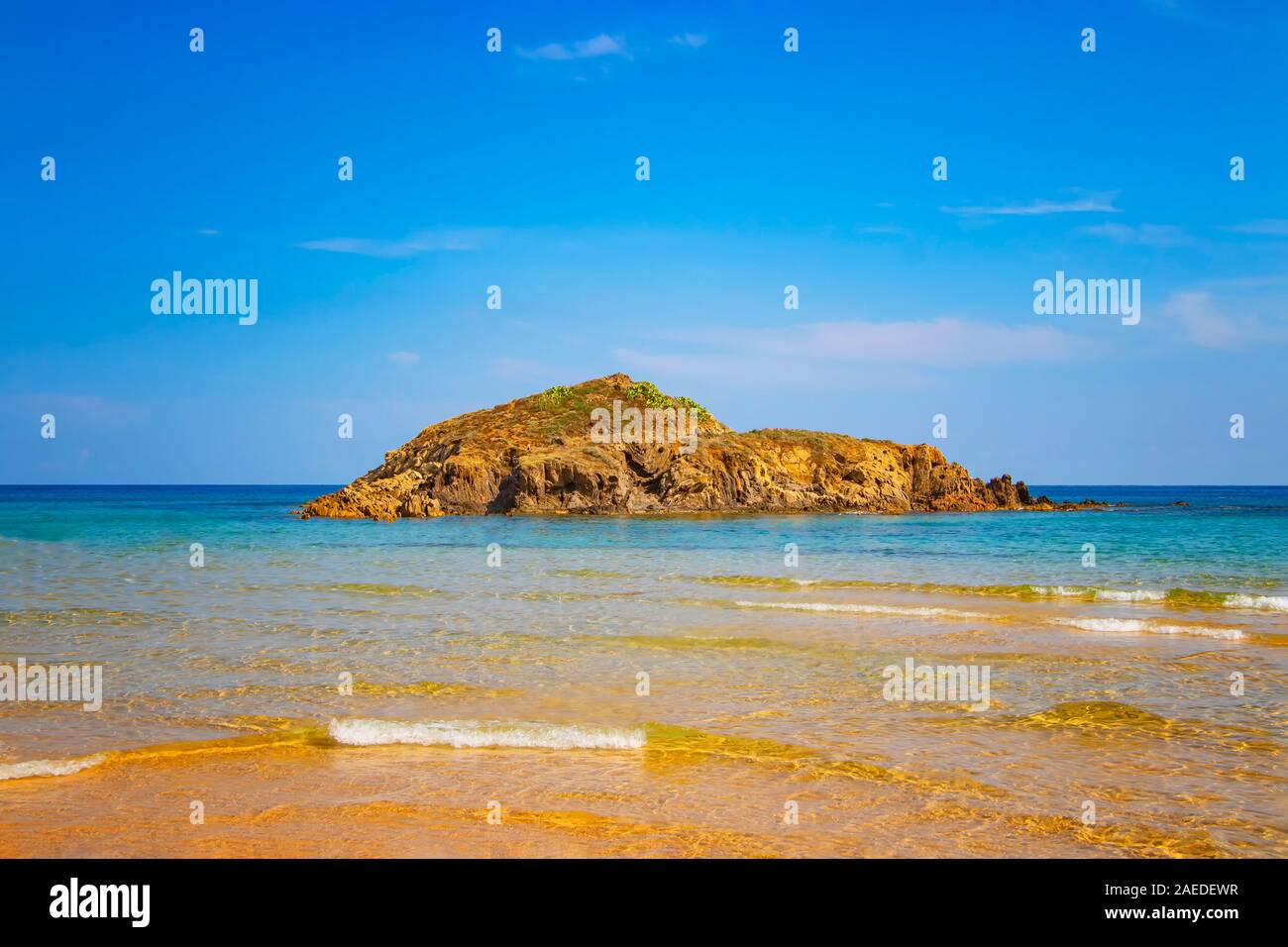 Small island on Chia beach in southern Italy. It is the most beautiful beach in Sardinia. Flamingos live in the wild. It is a long beach with golden Stock Photo