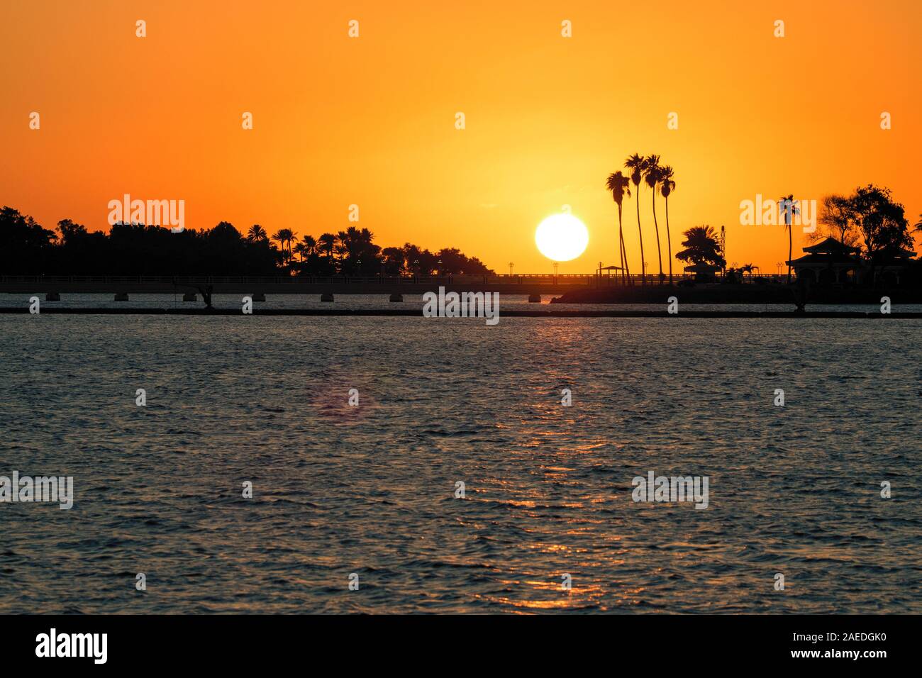 Scenic sunset with silhouettes of palm trees along the shore, seen from the South Corniche in Jeddah, Saudi Arabia Stock Photo