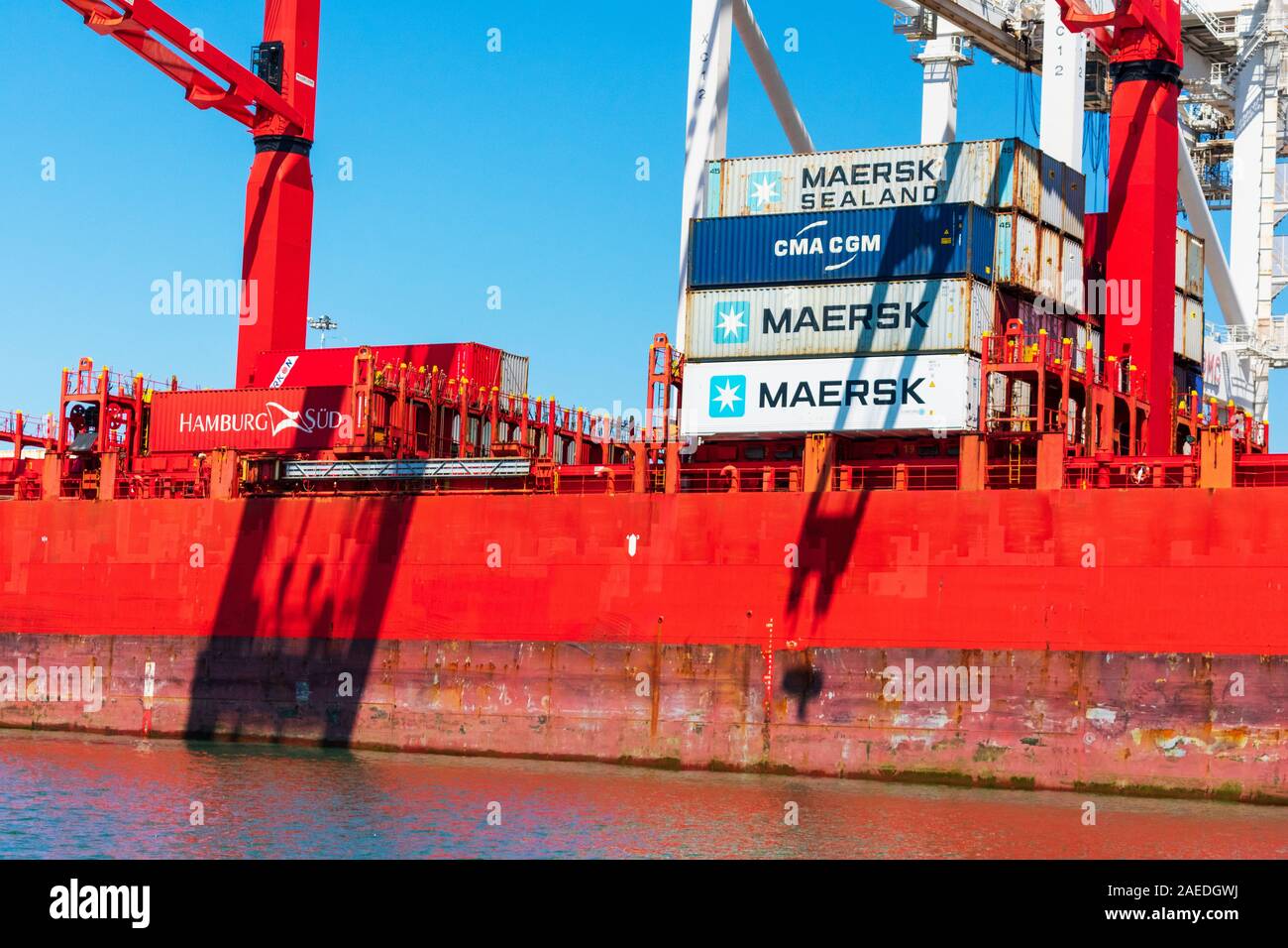 Maersk, CMA CGM, Hamburg Sud shipping containers stacked aboard bright red container ship - Oakland, California, USA - August, 2019 Stock Photo