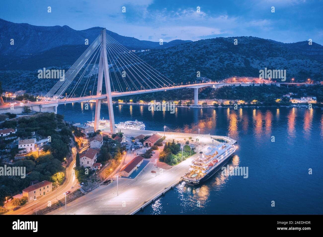 Aerial view of cruise ship in port and beautiful bridge at night Stock Photo