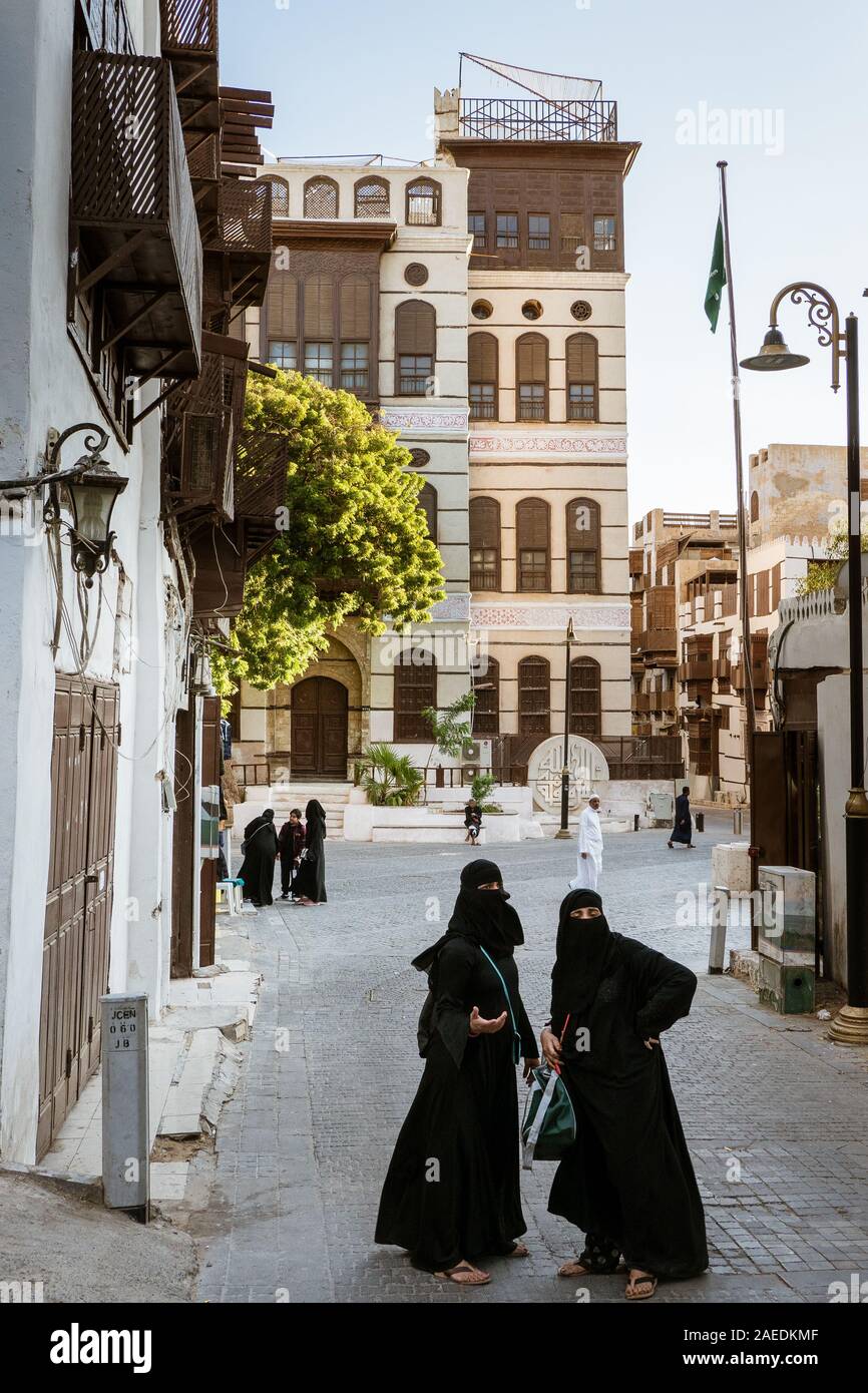 Arabic women in front of the Nasseef coral town house, Souk al Alawi Street in the historic district of Al Balad, Jeddah, Saudi Arabia, KSA Stock Photo
