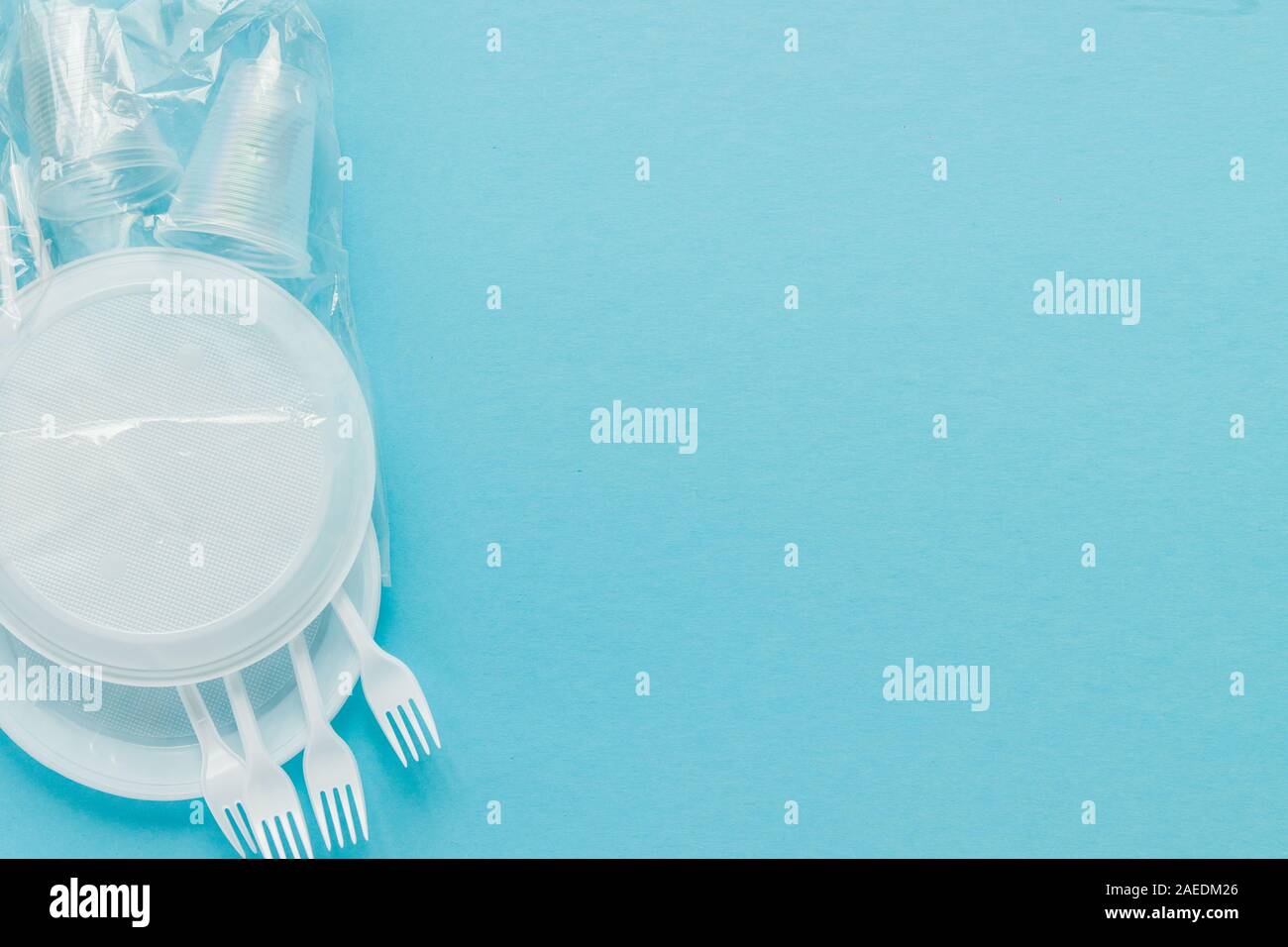 Plastic dishes on a blue background. Disposable tableware Stock Photo