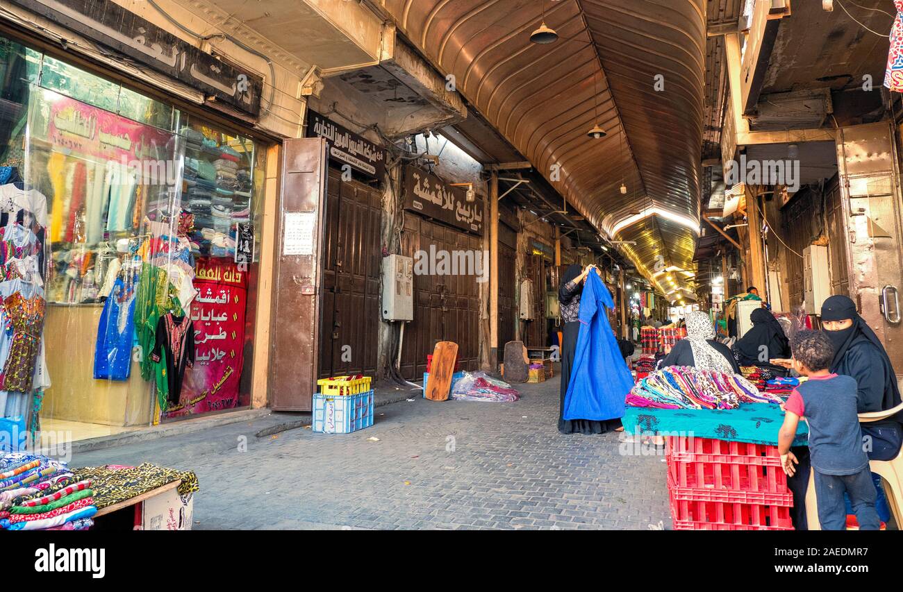 View of women sell textiles at the roofed section of the Souk Baab Makkah street market at the historic district Al Balad in Jeddah, KSA, Saudi Arabia Stock Photo