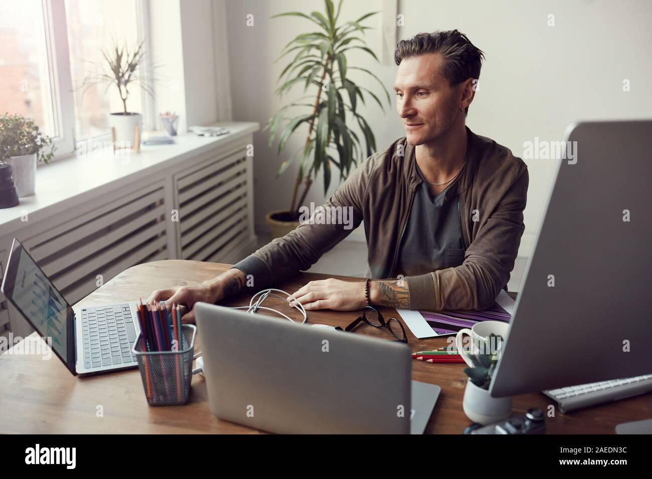 Portrait of handsome mature businessman using computers while ...