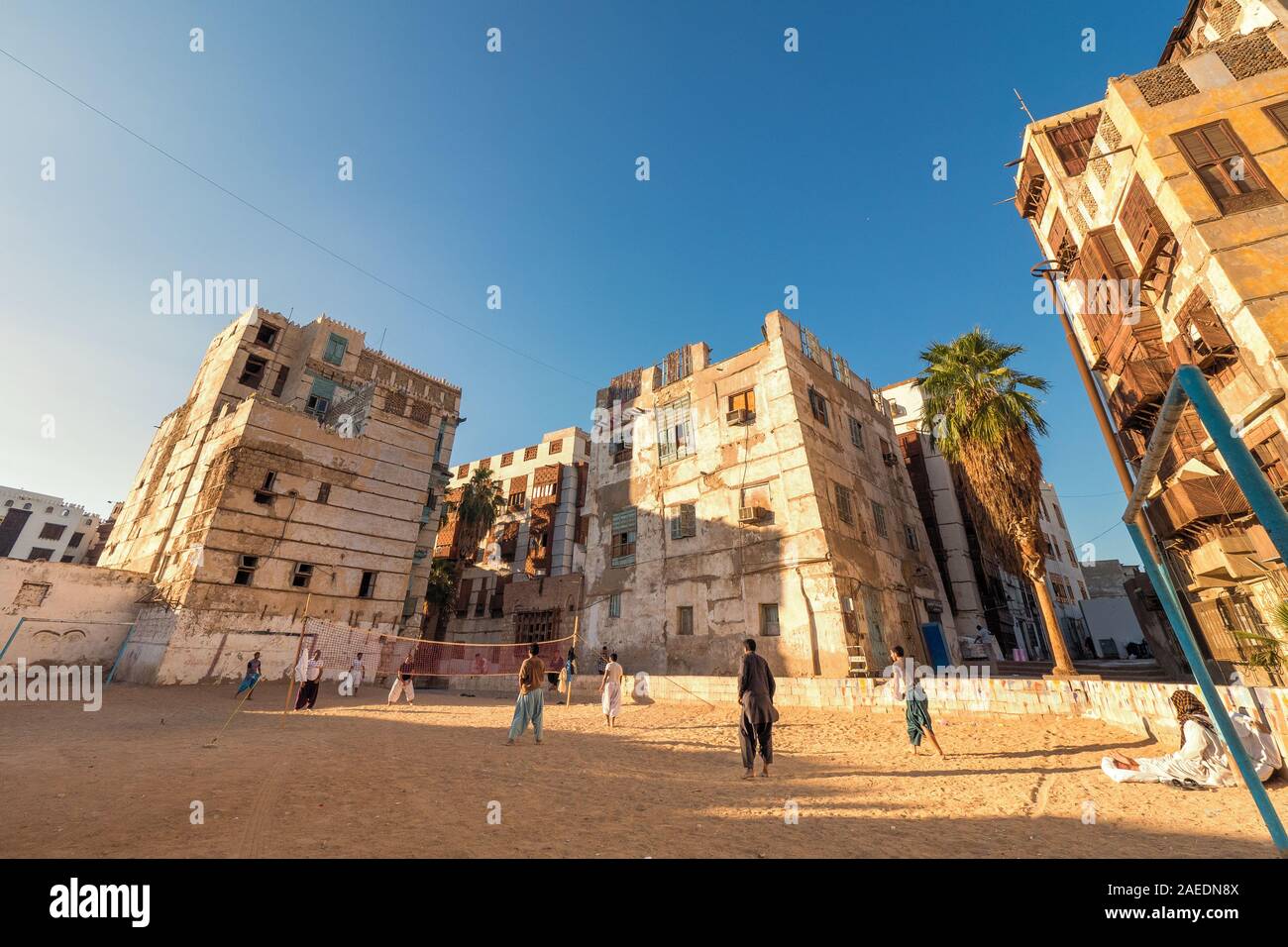 Arabic men playing beach volleyball on a grungy sports field in a residential area at the historic district Al Balad in Jeddah, Saudi Arabia, KSA Stock Photo