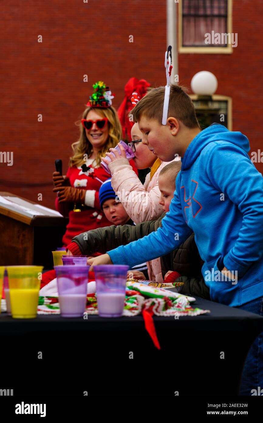 Gettysburg, PA / USA - December 7, 2019:  Children participate in Christmas Cookie eating contest on the steps of the public library in the downtown d Stock Photo