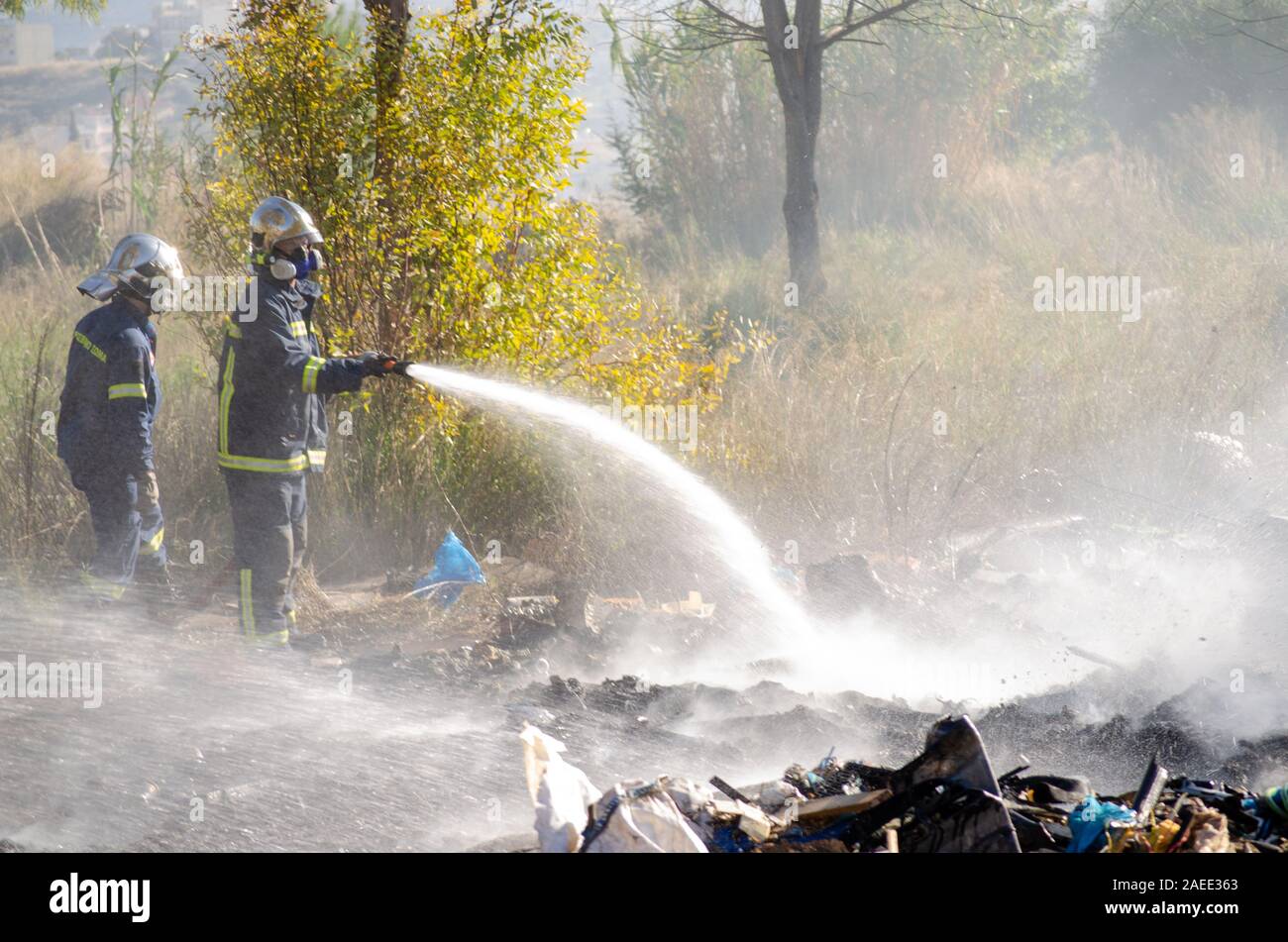 Menidi, Athens /Greece December 18 2019 illegal dumping areas, Firemen douse burning trash