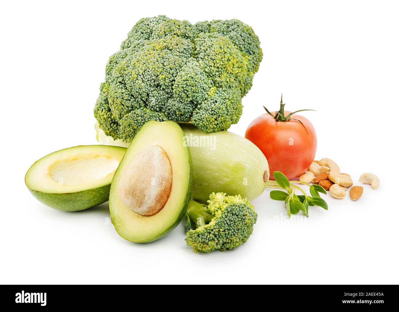 Heap of fresh vegetables and nuts with broccoli, avocado, tomato, squash and greens on white background Stock Photo