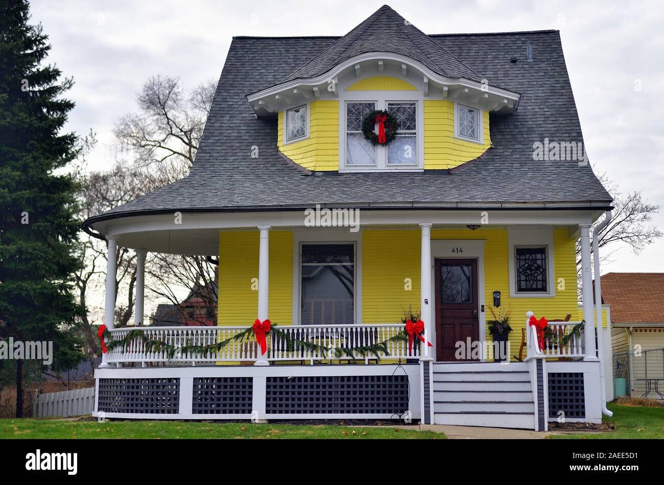 Elgin, Illinois, USA. A well maintained 19th century home with a wrap around porch presents a warm and inviting Christmas appearance. Stock Photo