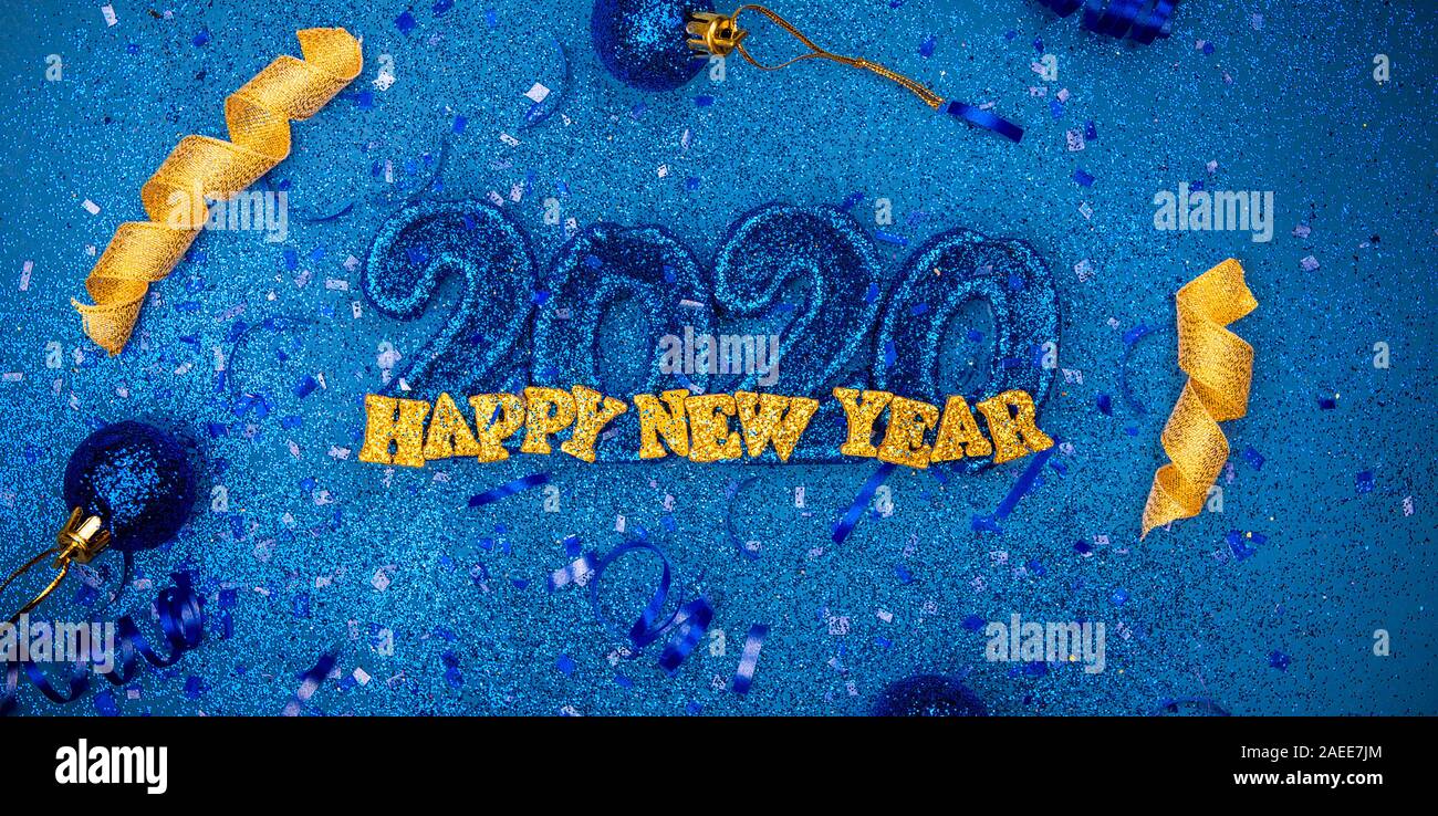 Sparkling new years 2020 3d letters with confetti and christmas bulbs - new years holiday concept image with copy space for text. Stock Photo