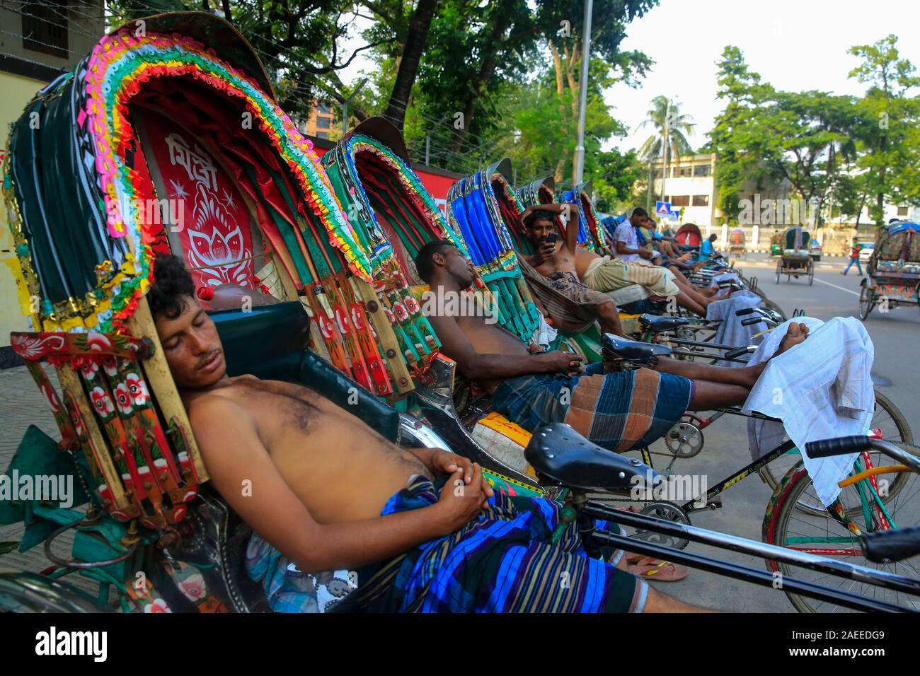 Bangladeshi Rickshaw pullers taking rest after their lunch in Dhaka on a hot summer day. Bangladesh Stock Photo