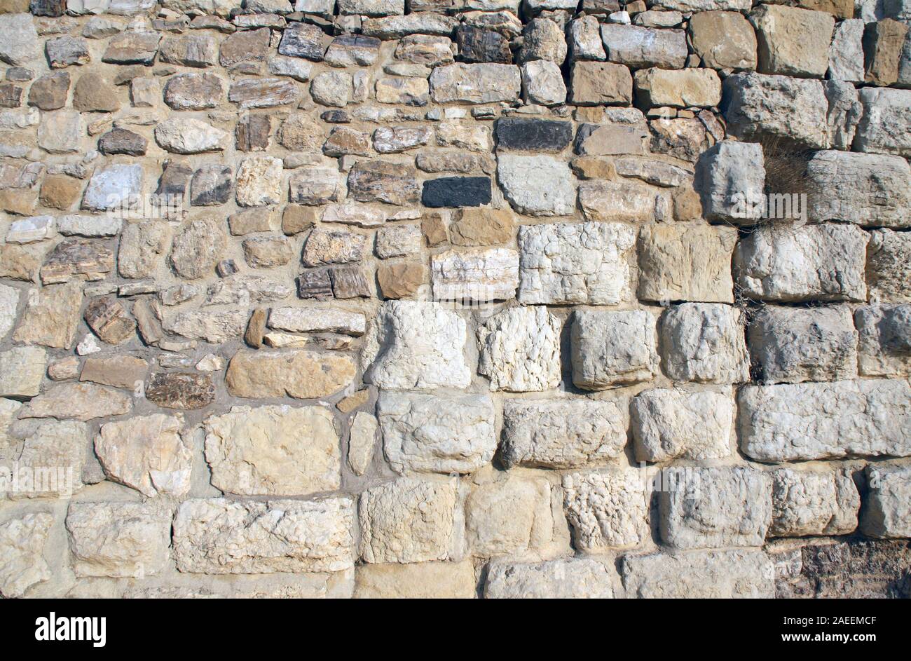 Ancient wall of stone blocks of different color and sizes Stock Photo