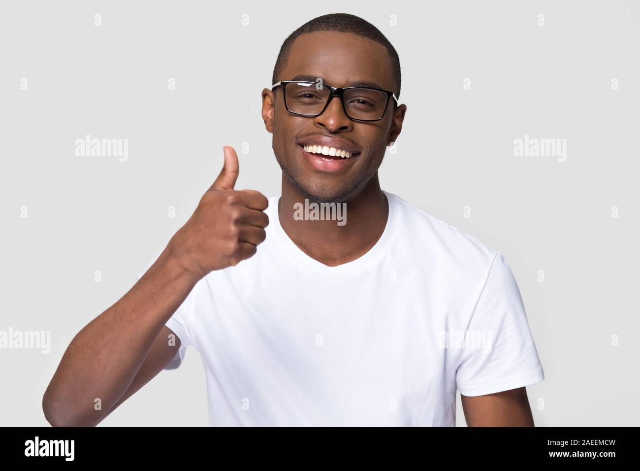African American man with healthy white smile showing thumbs up Stock Photo