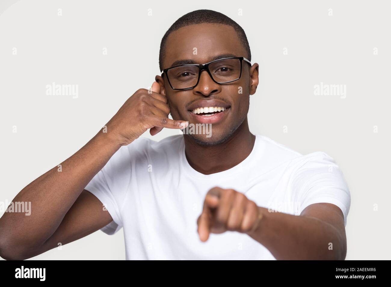Smiling African American man in glasses showing call me gesture Stock Photo