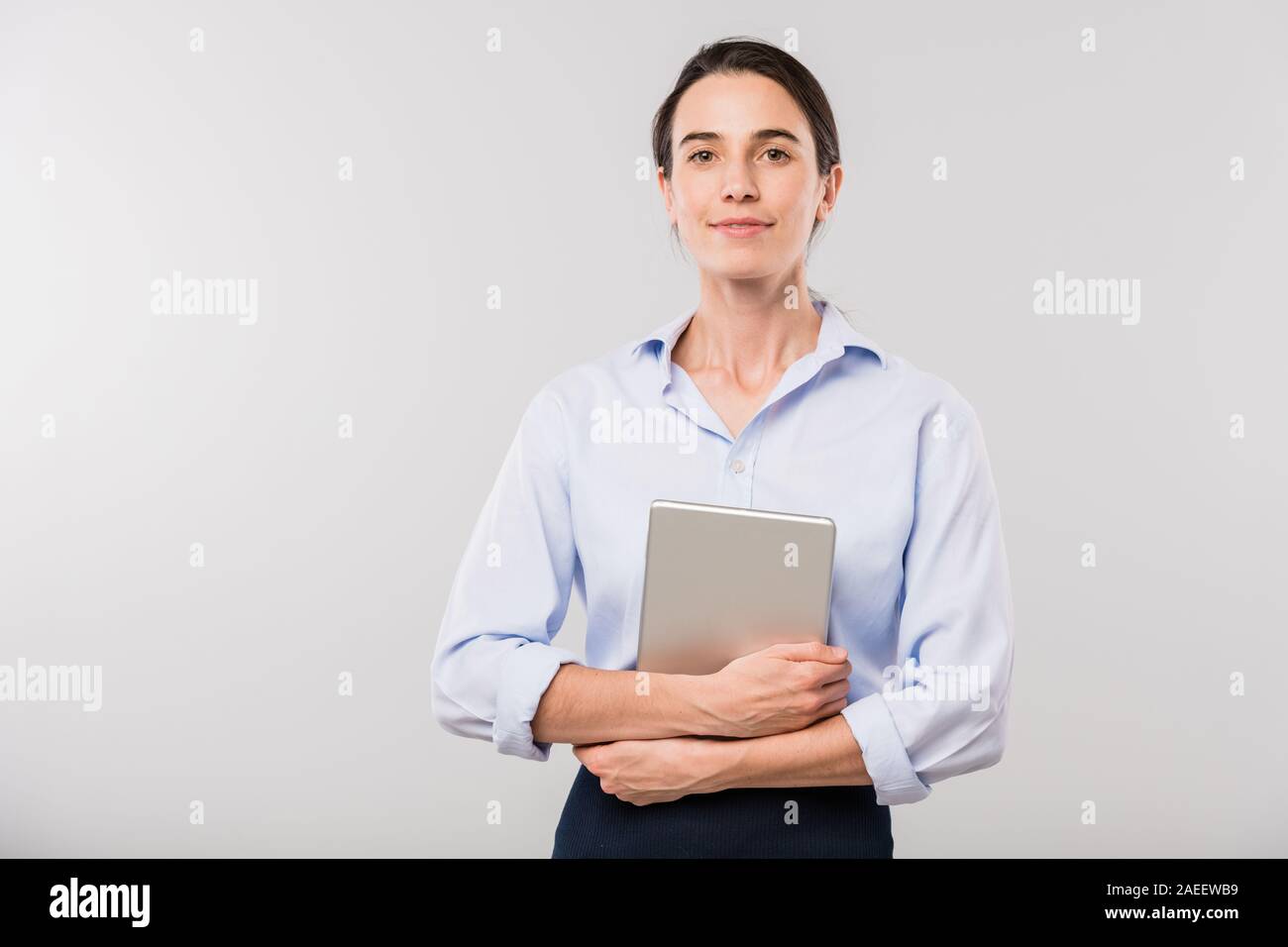 Young elegant businesswoman with touchpad standing in front of camera Stock Photo