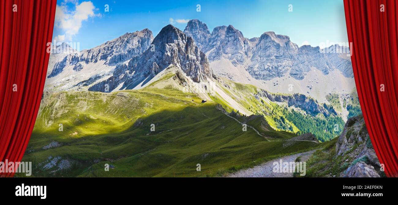 Open theater red curtains against a wonderful view of the Dolomites on Val di Fassa - On background the view of San Nicolò refuge in Contrin valley (I Stock Photo
