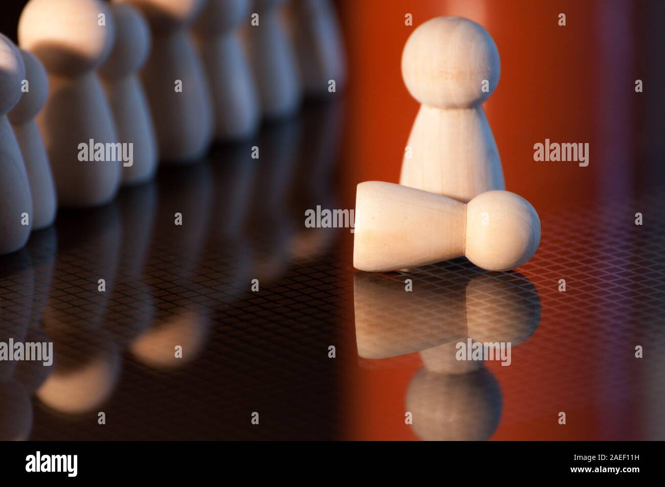 Wooden pawns Concept of social isolation, bullying. female discrimination, stalking and violence against woman. indifference,insensibility. Stock Photo
