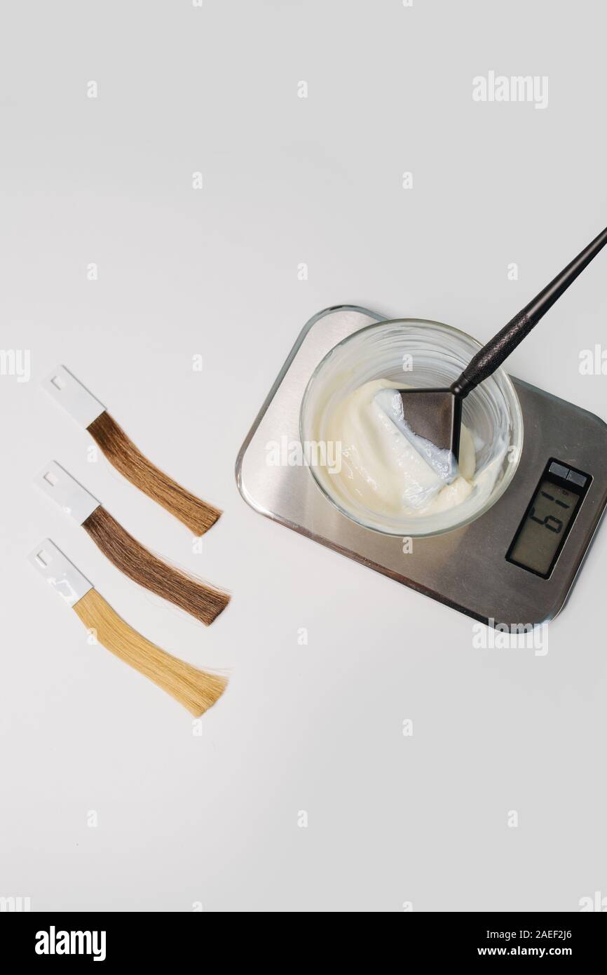 Bowl Of Die Developer On Scales Next To Locks Of Dyed Hair Samples
