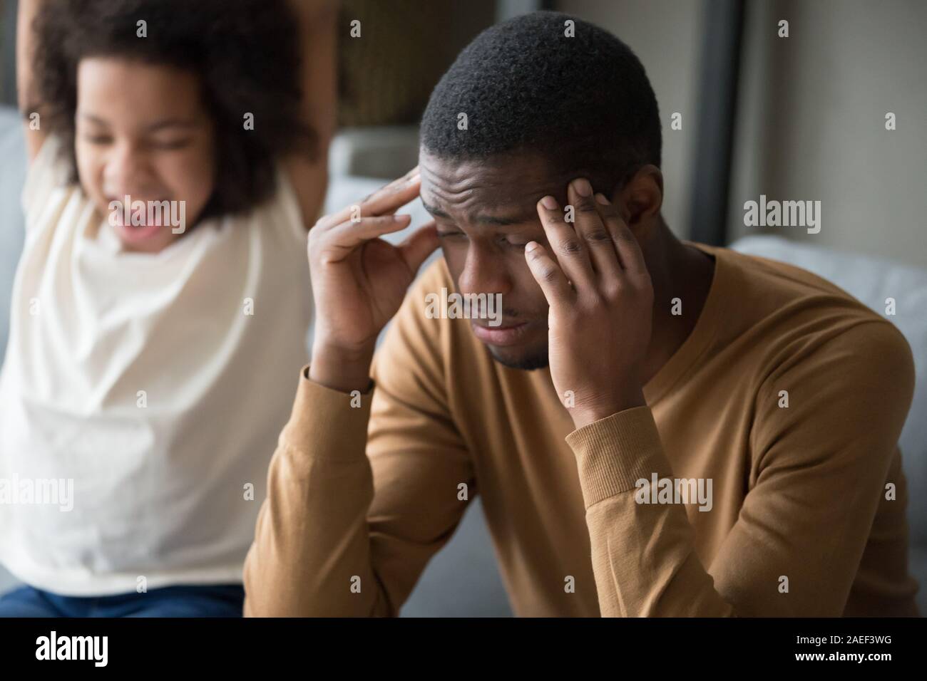 Tired black dad suffer from headache and disobedient daughter Stock Photo