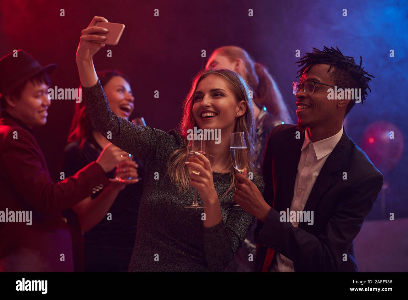 Beautiful mixed-race couple taking selfie photo on dnce floor while  enjoying party in night club Stock Photo - Alamy