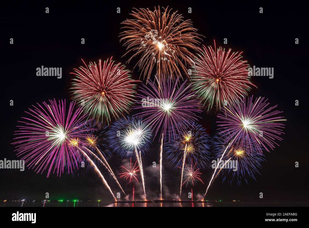 real fireworks festival in the sky for celebration at night over the sea at coast side for new year countdown celebration background Stock Photo