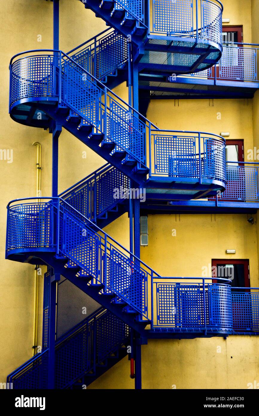 detail of a blue exterior staircase on a yellow building Stock Photo