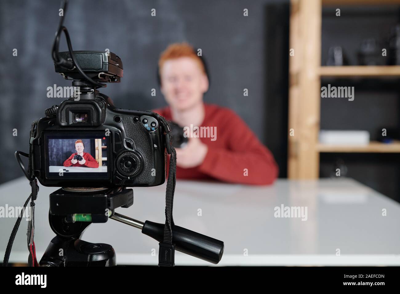 Screen of video camera with young vlogger or photographer holding photocamera Stock Photo