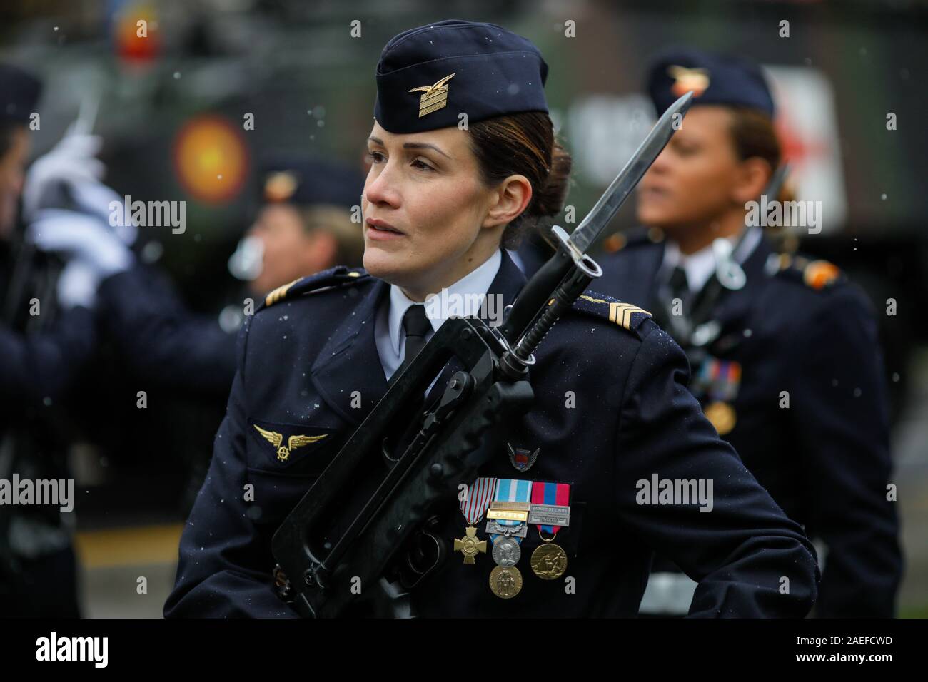 Bucharest, Romania - December 01, 2019: French female soldier attaches a bayonet to her gun during the Romanian National Day military parade during a Stock Photo