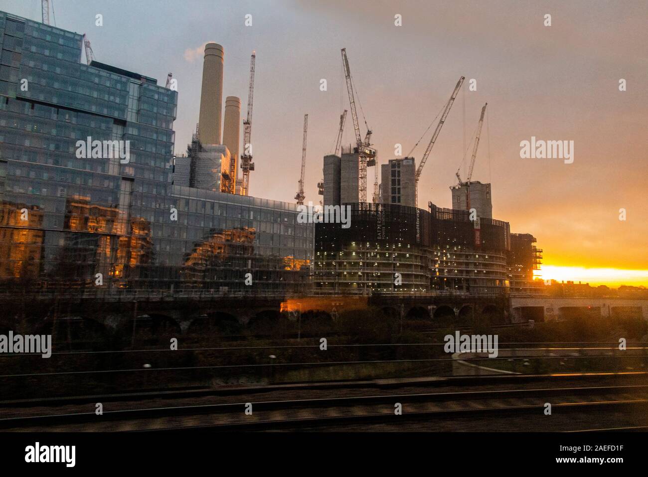 The sun rises behind Battersea Power Station and the new flats built