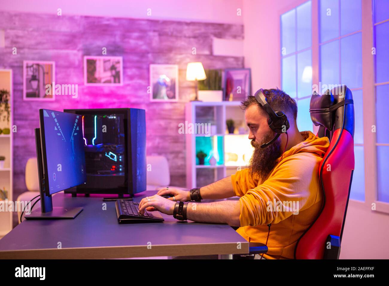 Hipster man playing professional video games in his room with colorful