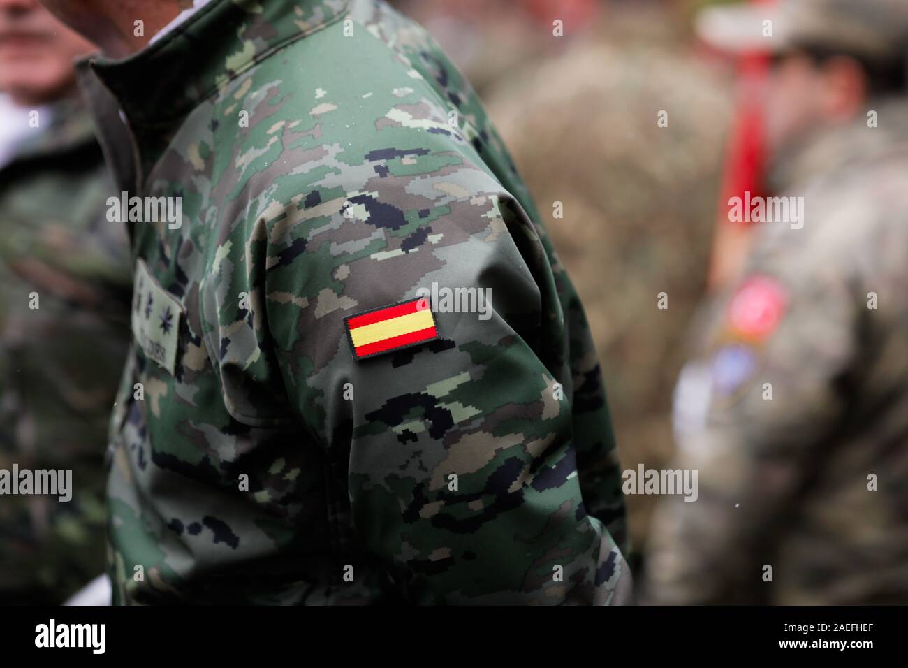 Details with the uniform and the flag on it of a Spanish soldier taking part at the Romanian National Day military parade. Stock Photo