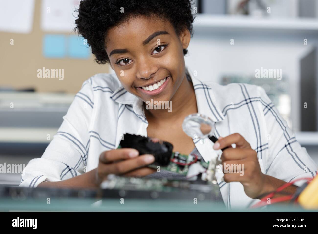 happy female digital electronic engineer examining computer pc in