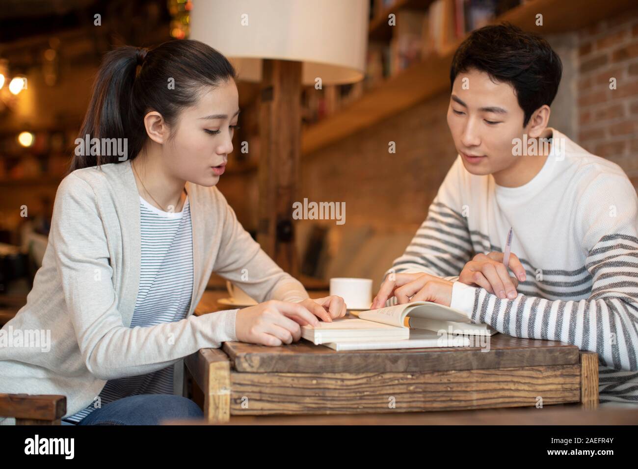 Young university students studying in coffee shop Stock Photo Alamy