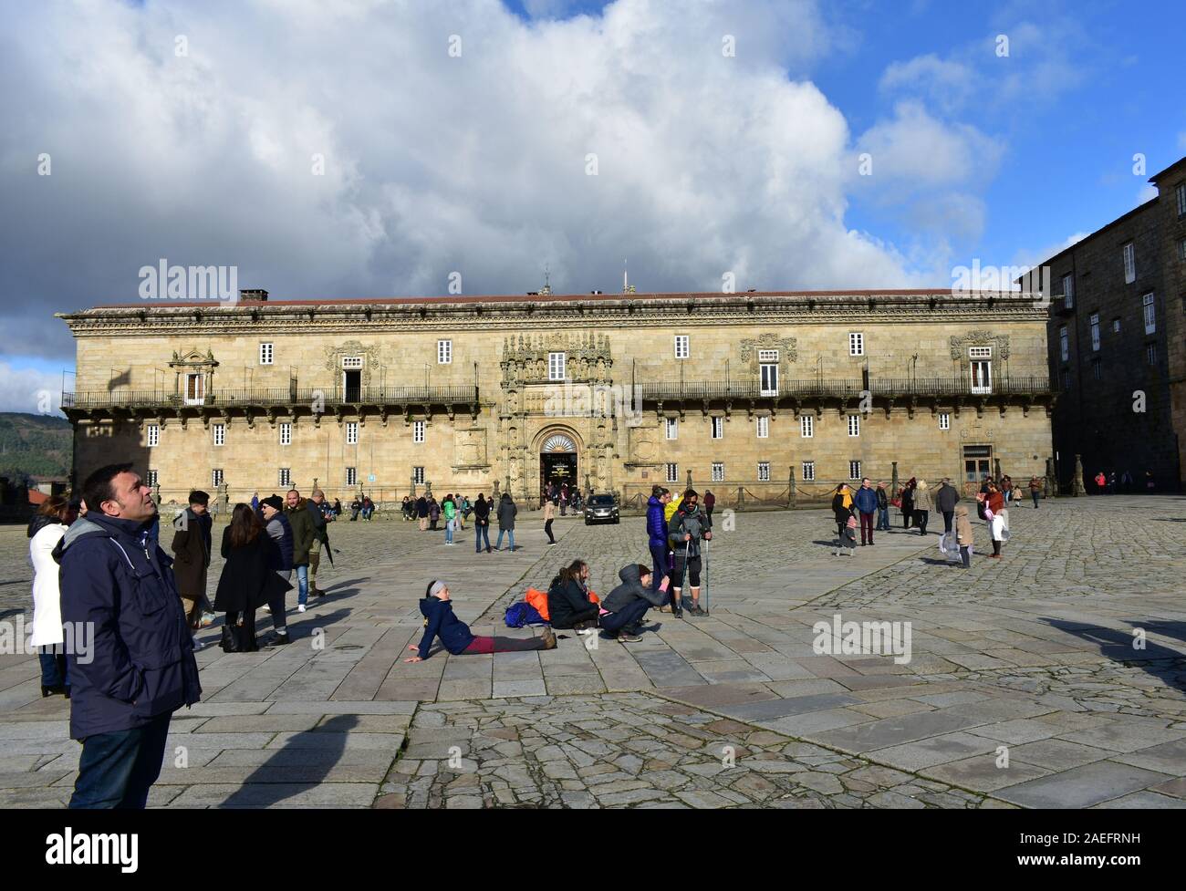Pilgrims taking pictures in front of Cathedral at Praza do Obradoiro with Hostal de los Reyes Católicos. Santiago de Compostela, Spain. Dec 1, 2019. Stock Photo