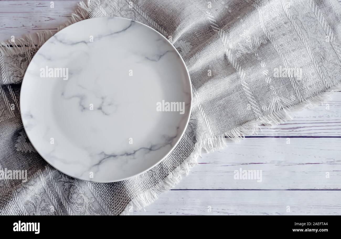 A white empty plate on a linen napkin Stock Photo