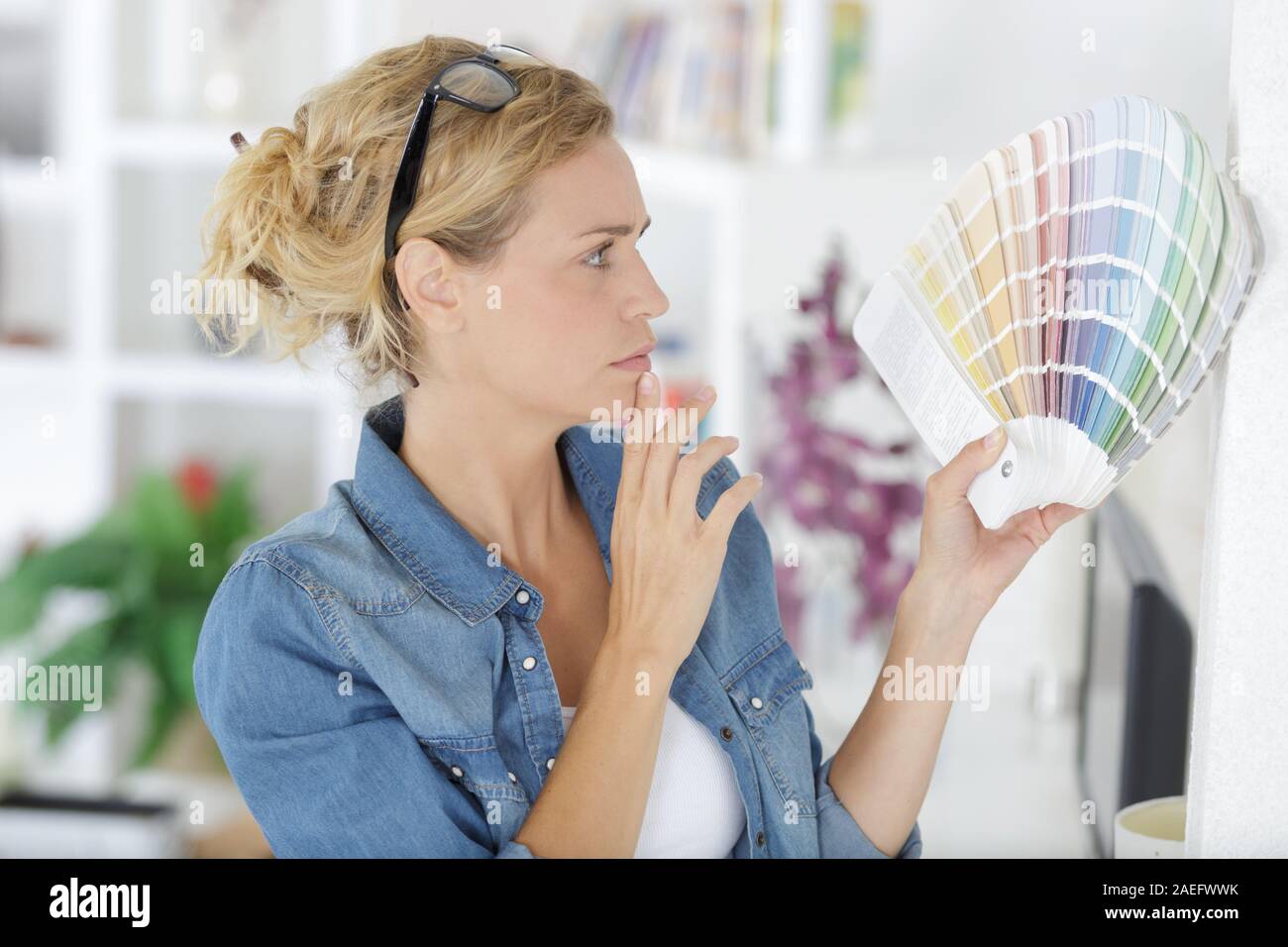 portrait of pretty blonde woman looking at color swatches Stock Photo