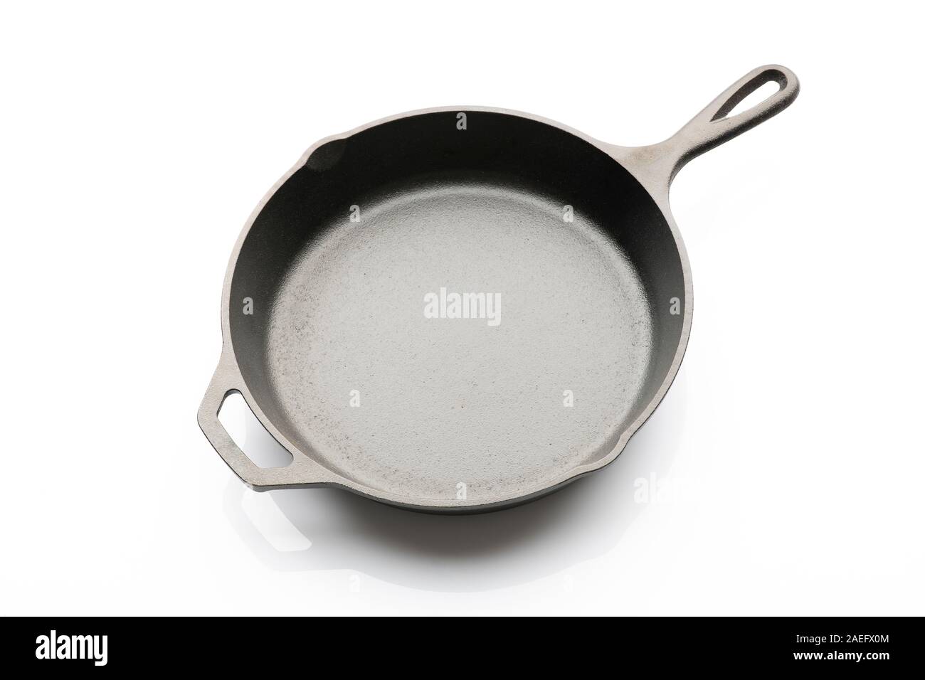 Top View of Seasoned Cast Iron Skillet on White Background Stock Photo
