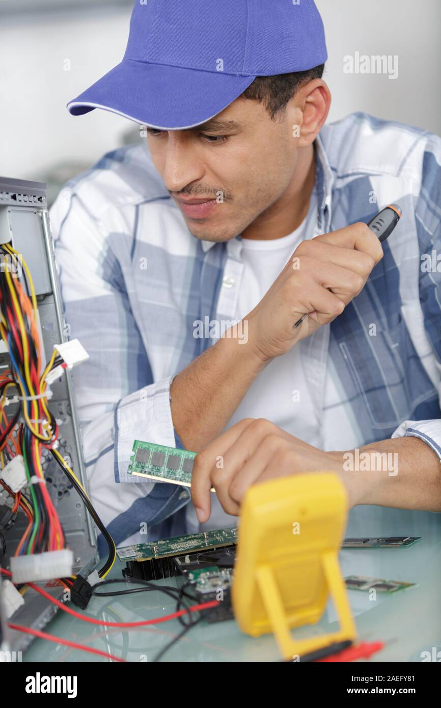 technicians working on broken computer in workshop Stock Photo