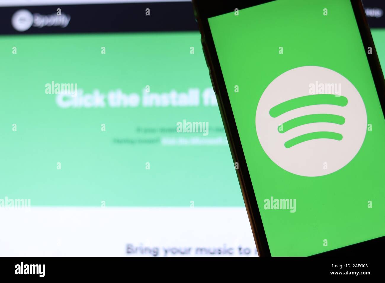Los Angeles, California, USA - 21 November 2019: Spotify logo on phone screen with icon on laptop on blurry background, Illustrative Editorial. Stock Photo