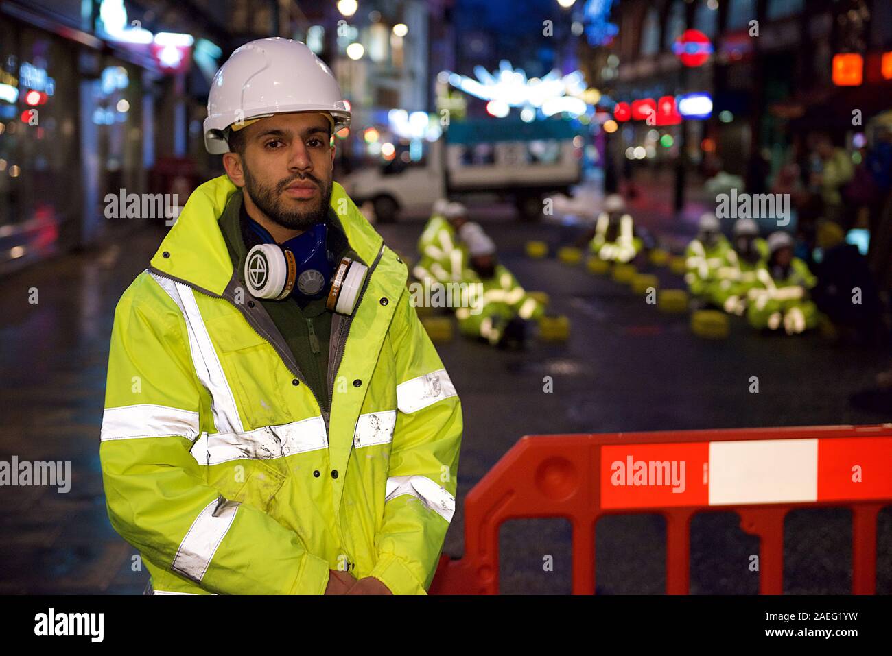 London, UK. 09th Dec, 2019. Extinction Rebellion 'Air That We Grieve' protest protester launched a pre-dawn action in Central London to protest illegal air quality levels in the capital. Dressed as highway maintenance workers, they blocked Cranbourne St and glued themselves to concrete blocks also glued to the road Credit: Gareth Morris/Alamy Live News Stock Photo