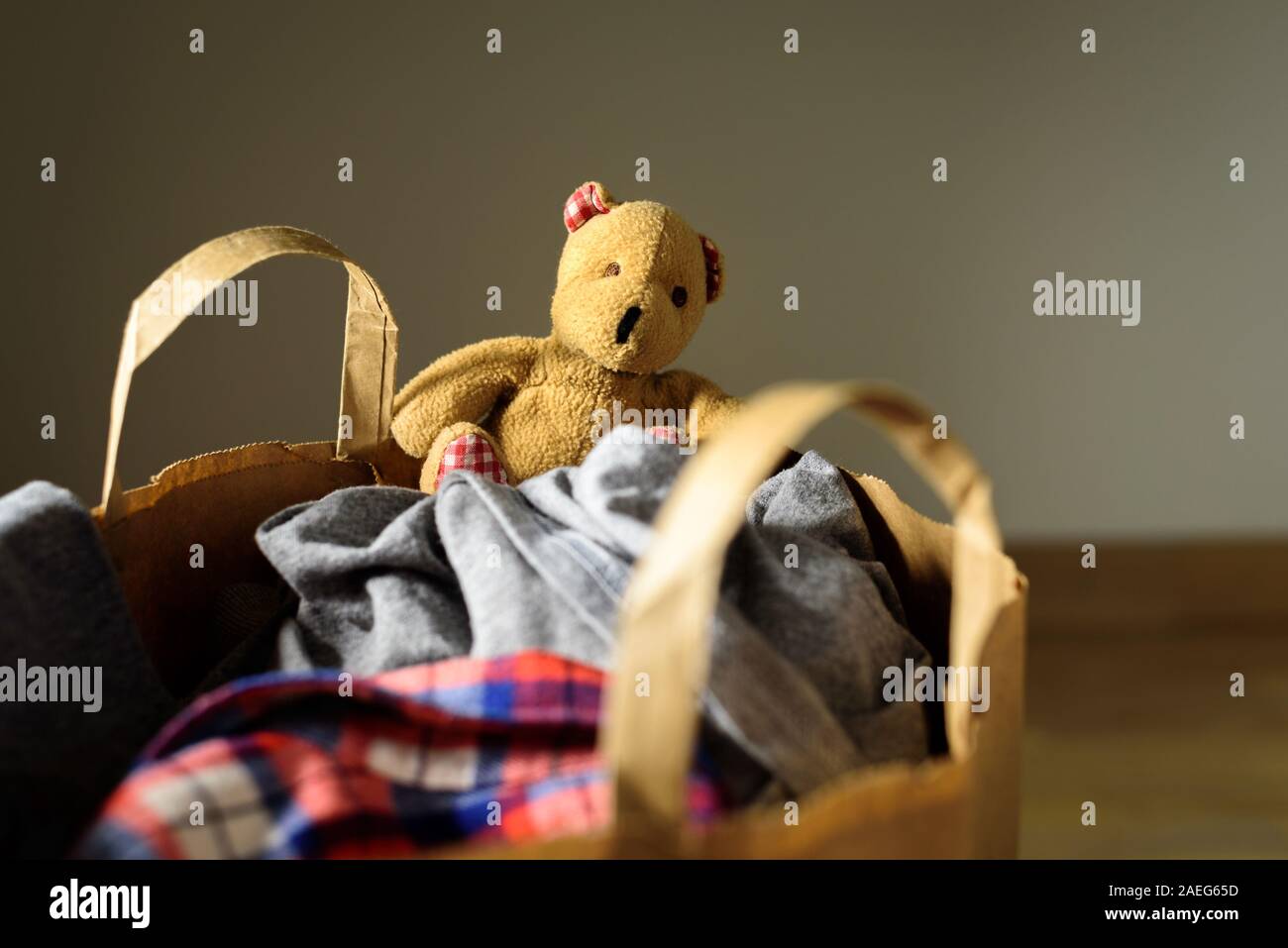 Paper bag with clothes donation. Old Bear toy Stock Photo