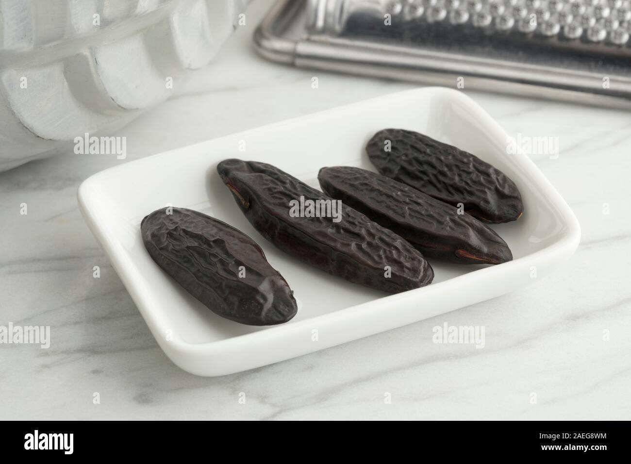 Tonka beans on a dish to be grated to cook Stock Photo Alamy