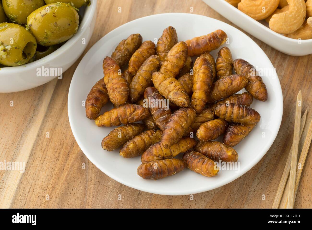 Bowl with salted crispy silkworms for a snack Stock Photo